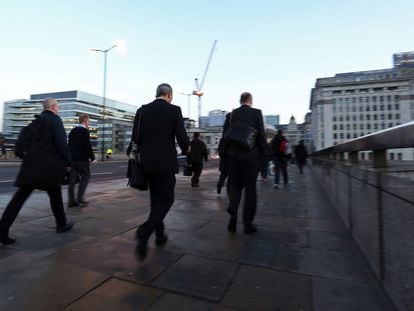 Varias personas cruzan el puente de Londres en direcci&oacute;n hacia a la City, el distrito financiero de Londres