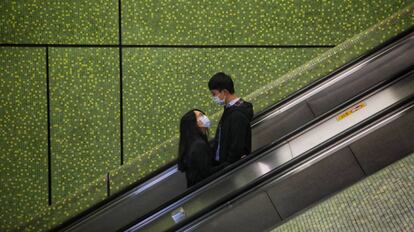 Una pareja vive su amor en tiempos ce coronovirus en un centro comercial de Hong Kong.