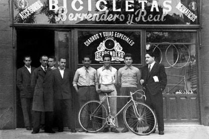 La inauguración de la tienda de bicicletas 'Berrendero y Real'. Julián Berrendero, el quinto de izquierda a derecha, agarra el sillín. /PÁGINA DE FACEBOOK DEDICADA AL CICLISTA