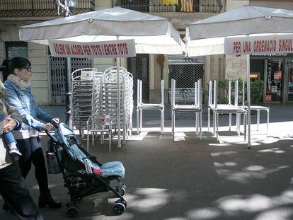 Una familia pasa por delante de una terraza cerrada. 