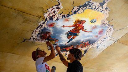 Los artístas Nadiemedicearte y PRËO dan los últimos retoques al mural que representa la victoria de la selección española de fútbol femenino en el Mundial 2023. Kike Rincón.