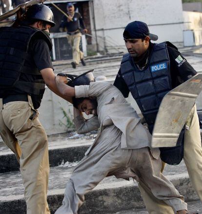 Policías pakistanís se enfrentan a un manifestante en la ciudad de Lahore tras protestar contra el film contra Mahoma.