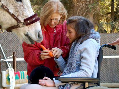 Teresa Xipell, hipoterapeuta en la Fundación Federica Cerdá, con una alumna.