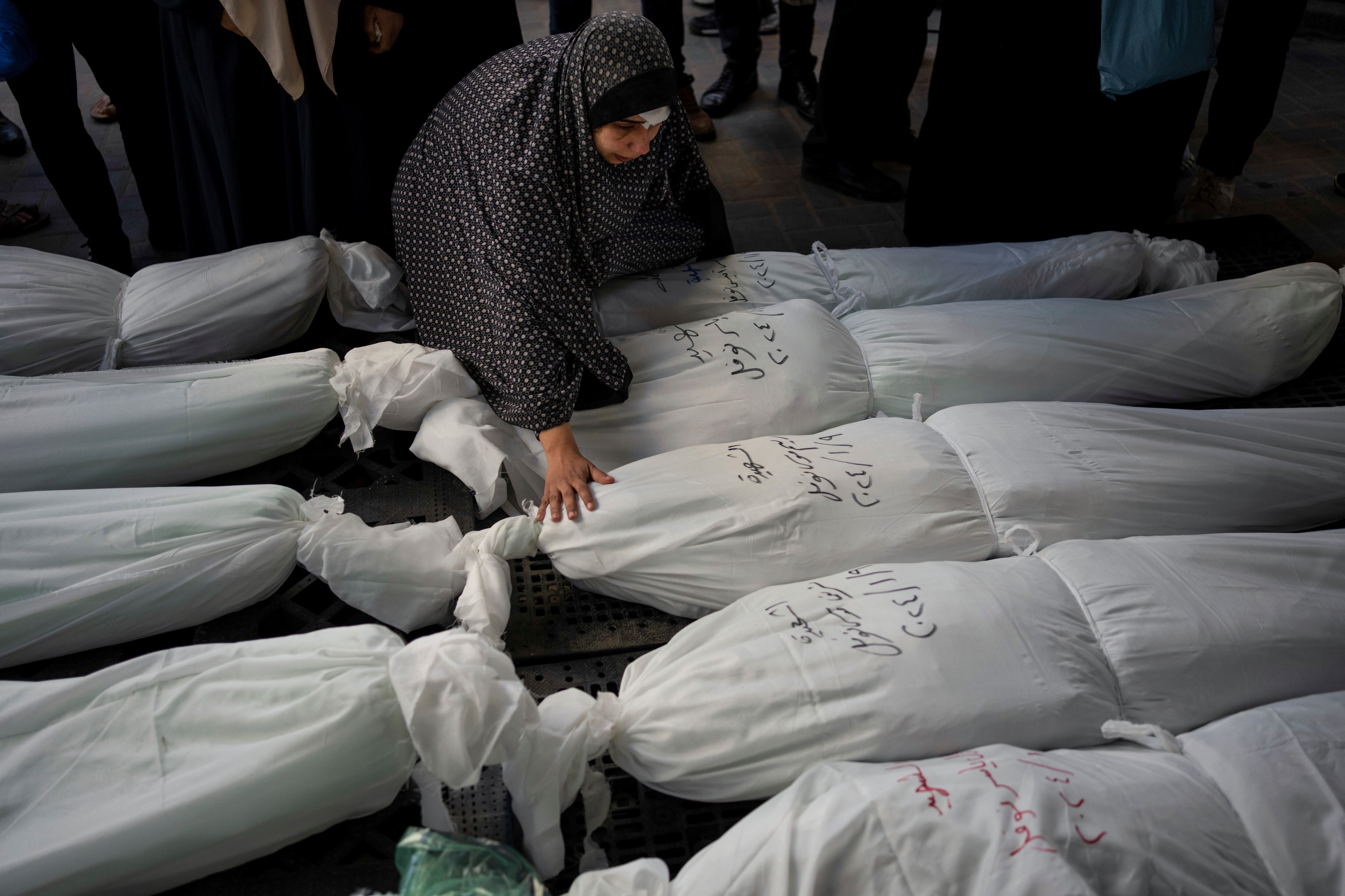 Un grupo de ciudadanos palestinos llora a sus familiares muertos en ataques israelíes a la Franja, este domingo.