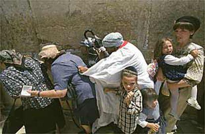 Mujeres y niños judíos corren a refugiarse en el momento en que los palestinos comenzaron a lanzar piedras sobre el Muro.