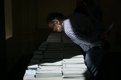 Un hombre mira las papeletas electorales en el colegio escuela Infant Jesus en Barcelona.