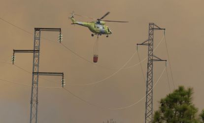 Un helicóptero colabora en los trabajos extinción del incendio declarado en el municipio palmero de Garafía este sábado.
