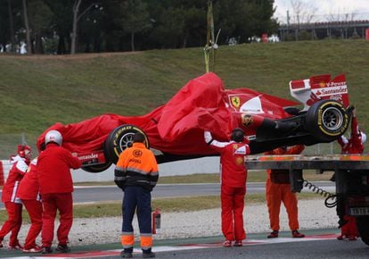 Los mecánicos recogen el monoplaza de Felipe Massa, tras averiarse durante el entrenamiento.