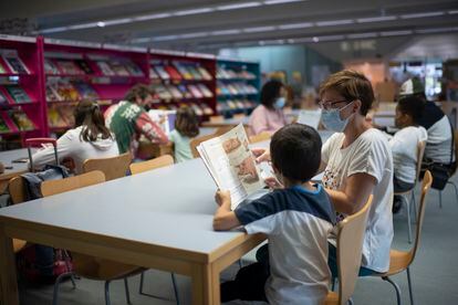 Varios niños junto a sus padres leyendo en la biblioteca Maria Moliner, en Madrid.


Foto: Inma Flores