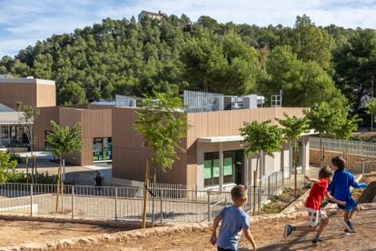 Unos niños juegan este miércoles en el colegio Serra Calderona, en Gilet, situado al lado del parque natural que lleva por nombre. Su diseño ha tratado de que no desentone en el entorno y se han utilizado en la medida de lo posible materiales de la zona, y árboles y plantas adaptadas al clima del lugar.