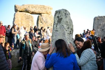 Visitantes tocando las piedras de Stonehenge en el solsticio de verano de 2023.