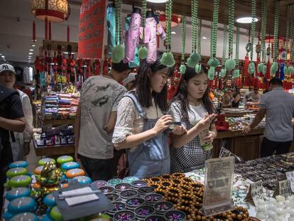 Ciudadanos chinos visitan una tienda en el distrito comercial de Wangfujing, en Pek&iacute;n.