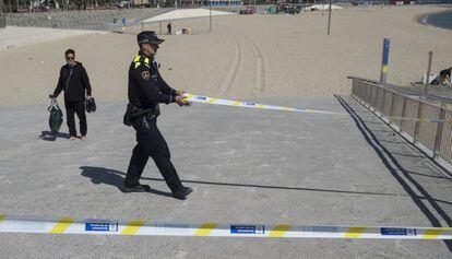 Un agent de la Guàrdia Urbana tanca l'accès a les platges el passat 15 de març.