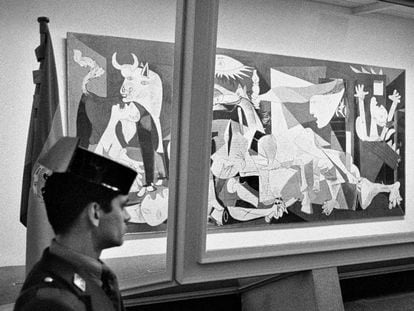 Un agente de la Guardia Civil vigila la urna blindada que protege el 'Guernica', obra de Pablo Picasso, en su presentación en el emplazamiento del Casón del Buen Retiro de Madrid, tras su llegada a España en 1981.