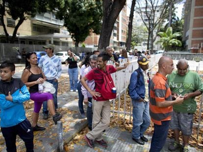 Ciudadanos hacen cola para comprar pan en Caracas.