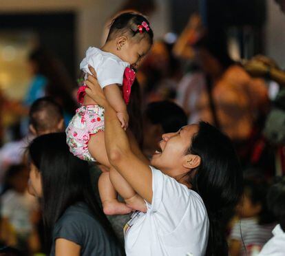 Una madre filipina levanta en brazos a su hija en Manila, el 23 de abril de 2016.