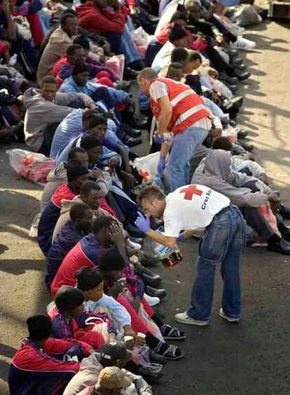 Miembros de la Cruz Roja atienden a algunos de los inmigrantes en el puerto de Los Cristianos.