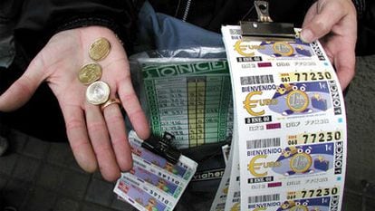 Un vendedor de la ONCE muestra unos cupones y unas monedas.