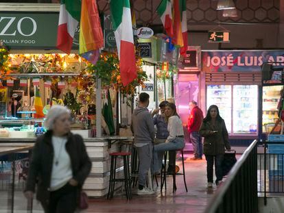 Tres personas toman el aperitivo en una de las mesas para degustación dispuestas en el mercado de la Cebada (Madrid) el 28 de marzo.