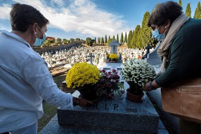 Unas mujeres dejan flores en una tumba en el cementerio de Toledo, este domingo. Desde algunos obispados hacen un llamamiento para vivir este momento de recuerdo a los familiares fallecidos con la "prudencia" que marcan las restricciones sanitarias.