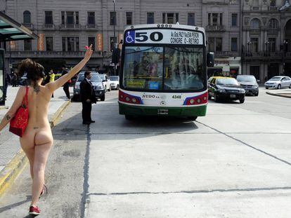Una de las integrantes de UrbaNudismo simula parar un bus.