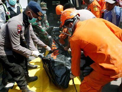 Miembros de los servicios de rescate retiran el cuerpo de una de las víctimas del terremoto en Indonesia.