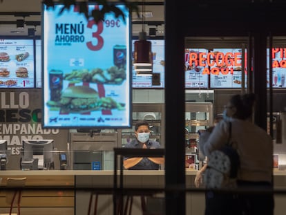 Una clienta se dispone a entrar en un restaurante de Madrid minutos antes del comienzo del estado de alarma.