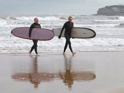 Dos surfistas, en la playa de San Lorenzo de Gijón, con la comunidad bajo aviso por bajas temperaturas.