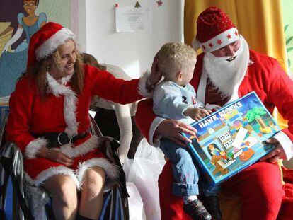 Uno de los niños que vive en el centro penitenciario Madrid VI recibe un regalo de Papá y Mamá Noel.