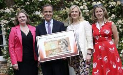 El gobernador del Banco de Inglaterra, Mark Carney (2i), acompañado por la parlamentaria conservadora Mary Macleod (i), la parlamentaria laborista Stella Creasy (2d) y la cofundadora de "Women's Room", Caroline Criado-Pérez, posa junto al diseño del nuevo billete de diez libras, que muestra el rostro de la novelista británica Jane Austen, durante la presentación del mismo, en el Museo Jane Austen, en Chawton, Reino Unido, 24 de julio de 2013.