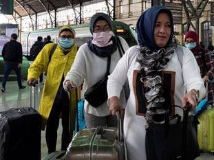 Tourists with face masks arrive at the train station in Valencia.