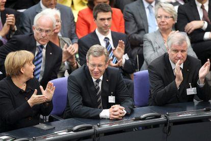 La canciller alemana, Angela Merkel, y el presidente de Baviera y líder de la CSU, Horst Seehofer (derecha), aplauden a Christian Wulff tras la segunda votación.