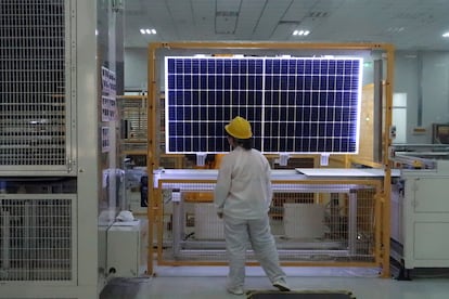 Un trabajador realiza un control de calidad de un módulo solar en una fábrica de LONGi, en China.
