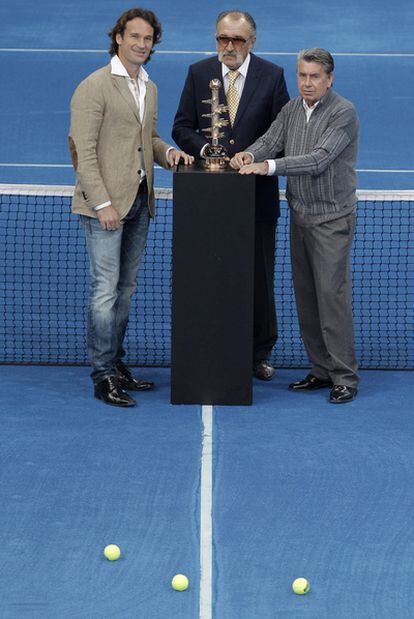 El extenista Carlos Moyá  posa junto al promotor del Master 1000 de Madrid de tenis, el rumano Ion Tiriac, y el director del torneo, Manolo Santana, con motivo de la presentación de la pista azul de tierra batida sobre la que se disputará esta competición el próximo año.