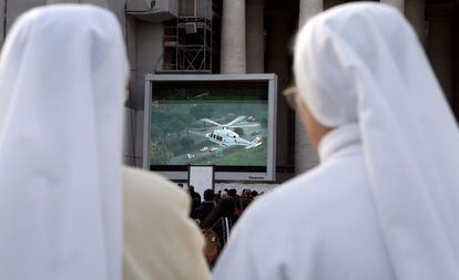 Unas monjas siguen por una pantalla de televisión, en la ciudad del Vaticano, la marcha del helicóptero que lleva al papa Benedicto XVI a la residencia papal de verano en Castel Gandolfo.