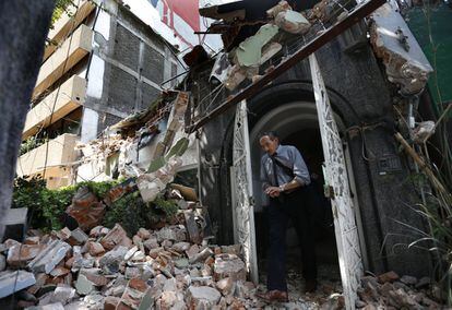 Un home surt per la porta d'un edifici esfondrat després del sisme a la colònia de Condesa, a Ciutat de Mèxic.