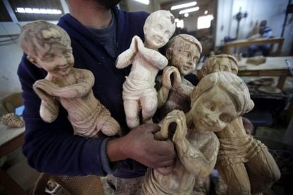 Un carpintero muestra figuras cristianas en un taller en Belén, Palestina.