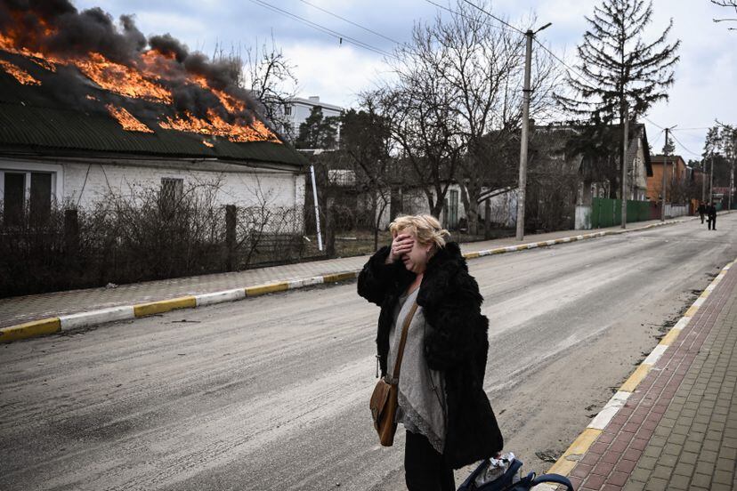 Ucrania. Una mujer se lamenta frente a una casa en llamas en la ciudad de Irpin, en las afueras de Kiev, en marzo de 2022. Más de 1,2 millinones de personas han huido del país tras la invasión del ejército ruso iniciada a finales de febrero del pasado año. 