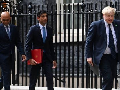 Boris Johnson, en primer plano, seguido de los dimitidos ministros de Finanzas, Rishi Sunak, y de Salud, Sajid Javid, en el exterior de la sede del Gobierno.
