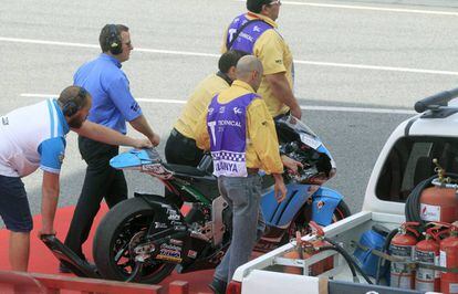 Operarios retiran la moto de Luis Salom. 