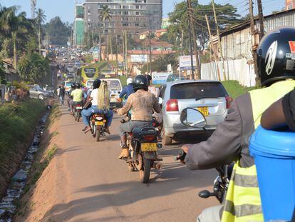Mototaxis, conocidos localmente como 'boda-boda', pasan junto a vehículos Kampala (Uganda).