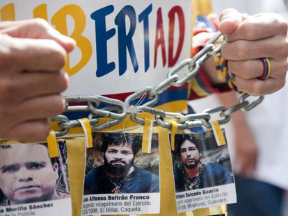 Un hombre muestra fotos de los polic&iacute;as secuestrados por las FARC en una multitudinaria protesta realizada contra esa guerrilla el pasado 6 de diciembre.