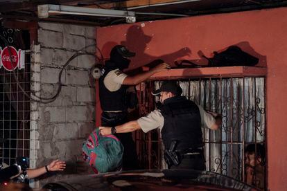 Two police officers search for weapons and drugs during the curfew imposed in Ecuador in the Flor de Bastión neighborhood of Guayaquil.  