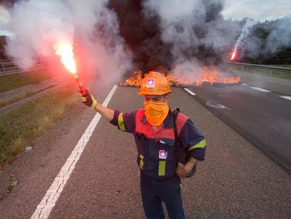 Un trabajador de la planta de Alcoa San Cibrao enciende una bengala durante una protesta ayer en la autovía A6 en Outeiro de Rei (Lugo).