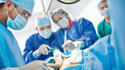 Un equipo médico practica una cesárea en un parto.
