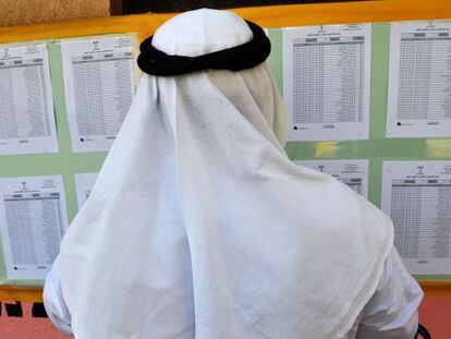 Un saudí busca su nombre en el listado de votantes.
