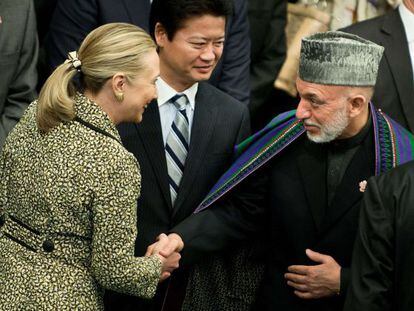 La secretaria de Estado de EE UU, Hillary Clinton, saluda al presidente afgano, Hamid Karzai, en presencia del ministro de Exteriores de Jap&oacute;n, pa&iacute;s anfitri&oacute;n de la Conferencia de donantes, hoy en Tokio. 