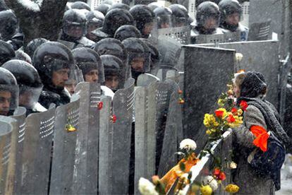 Una mujer partidaria del líder opositor oficialmente derrotado se dirige a los policías que protegen el edificio presidencial en Kiev.