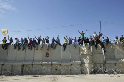 Jóvenes palestinos celebran encaramados a un muro en Rafá la liberación de presos palestinos.
