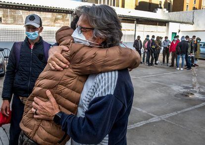 Los migrantes abrazan al párroco Jorge Hernández este martes como despedida y agradecimiento por haberlos acogido provisionalmente.